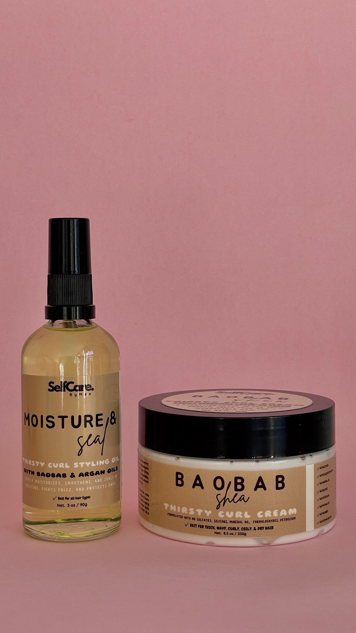 Two haircare products on a solid pink background: a clear bottle of SelfCare by Mee Moisture & Seal hair styling oil with a black pump top, and a beige jar of BAObAB Thirsty curl Cream with a black lid.