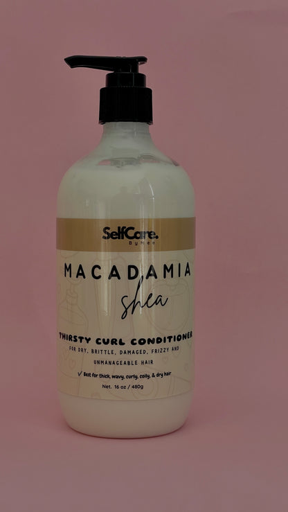 A bottle of SelfCare by Mee Macadamia Shea Thirsty Curl Conditioner, featuring a white bottle with a black pump and a beige and white label, set against a solid dusty pink background.
