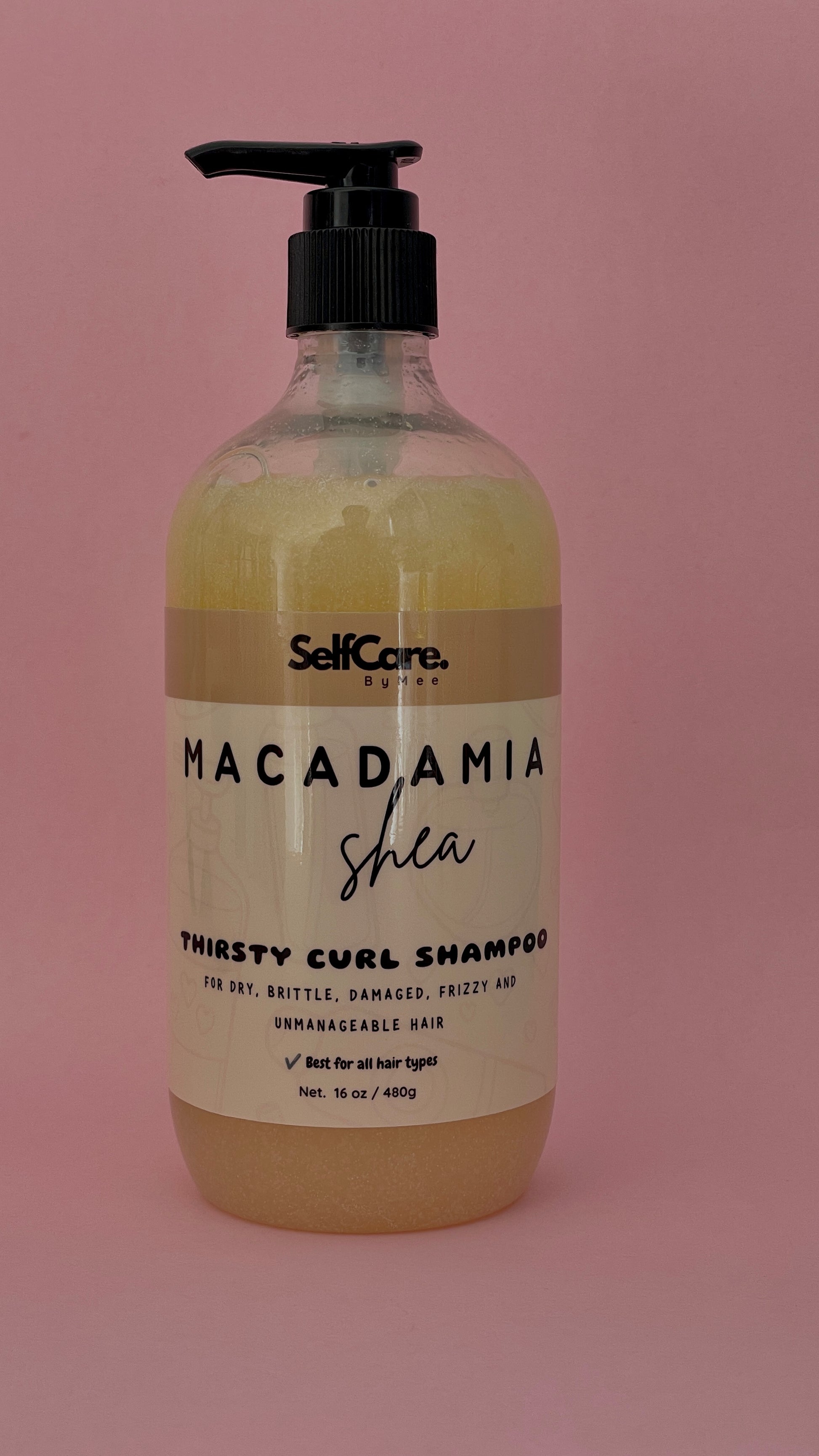A bottle of SelfCare by Mee Macadamia Shea Thirsty Curl Shampoo with a black pump dispenser, set against a solid pink background.